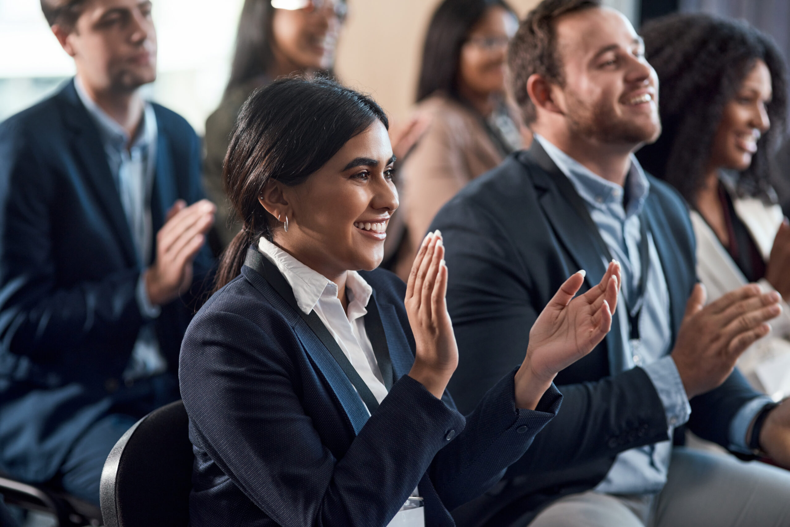 Shot of a group of young businesspeople clapping during a conference in a modern office.