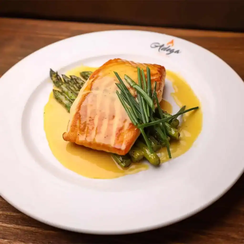 Delicious grilled fish served with fresh asparagus and herbs, drizzled with a flavorful sauce. Perfe.