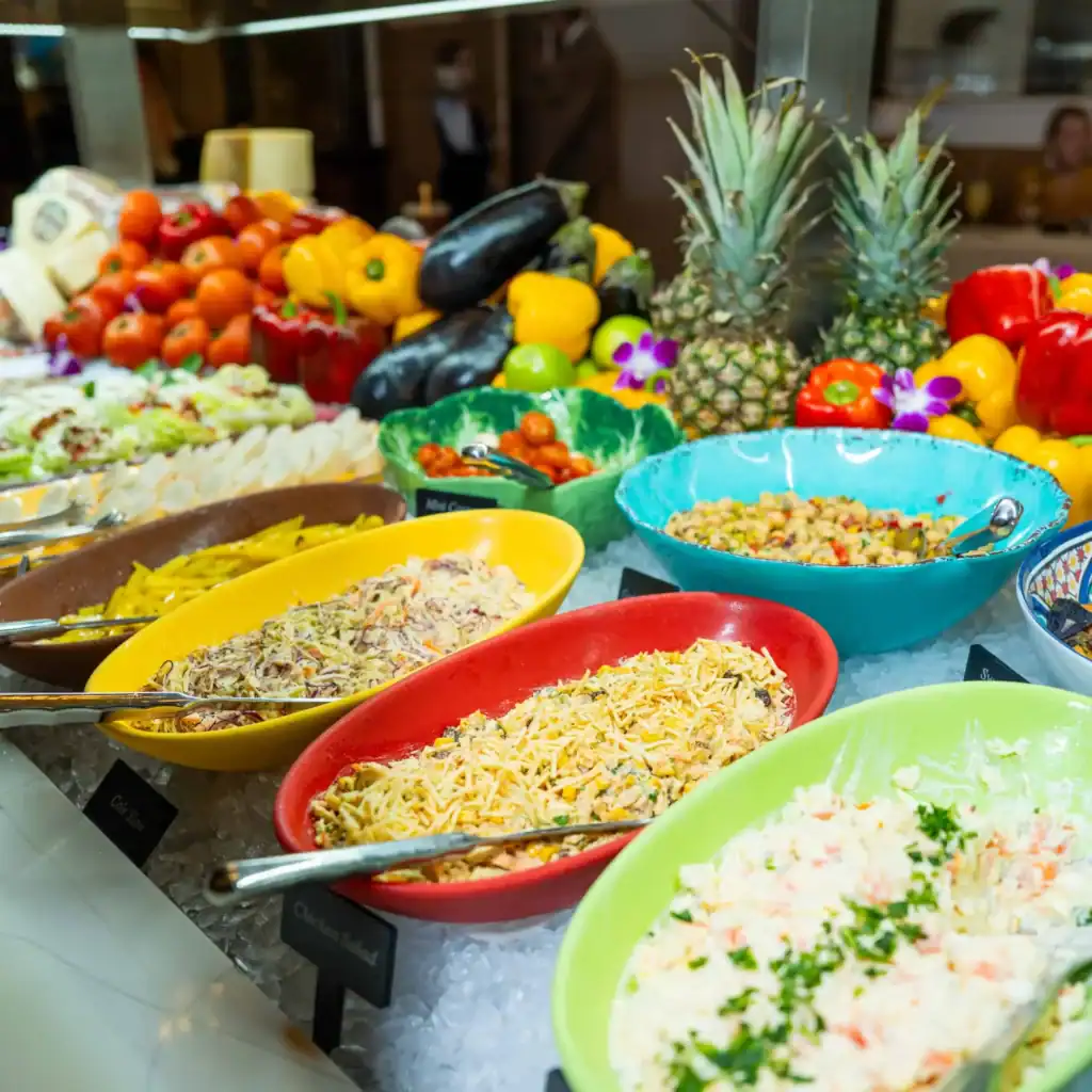 Fresh fruit and salad buffet at Adega Gaucha restaurant, featuring pineapples, tomatoes, and colorfu.